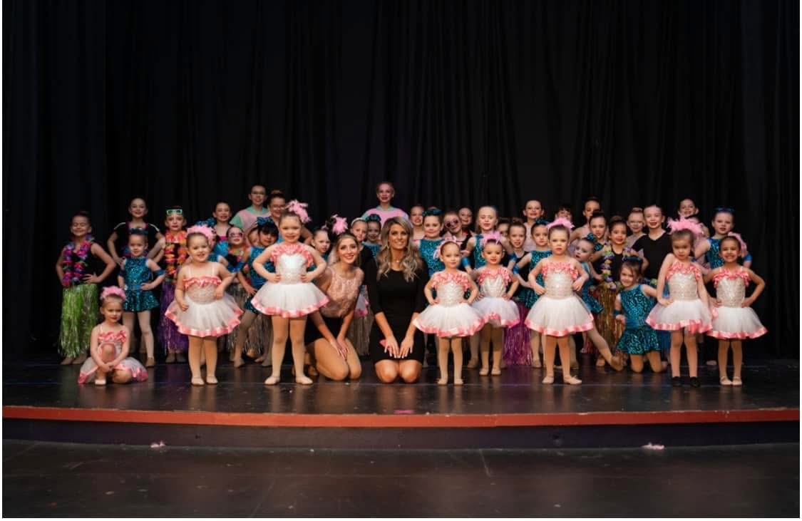 Director Kaleah Moates on stage with her dancers after a recital performance